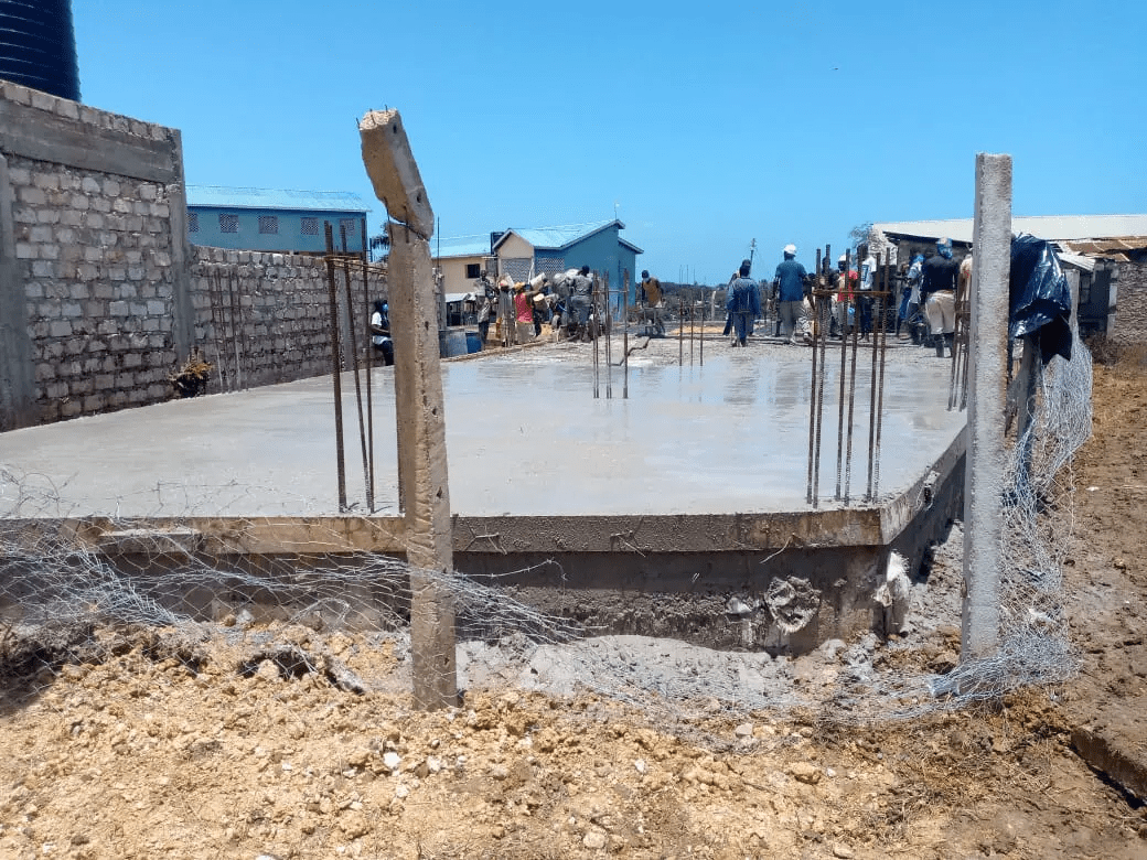 A group of people standing around a building under construction.